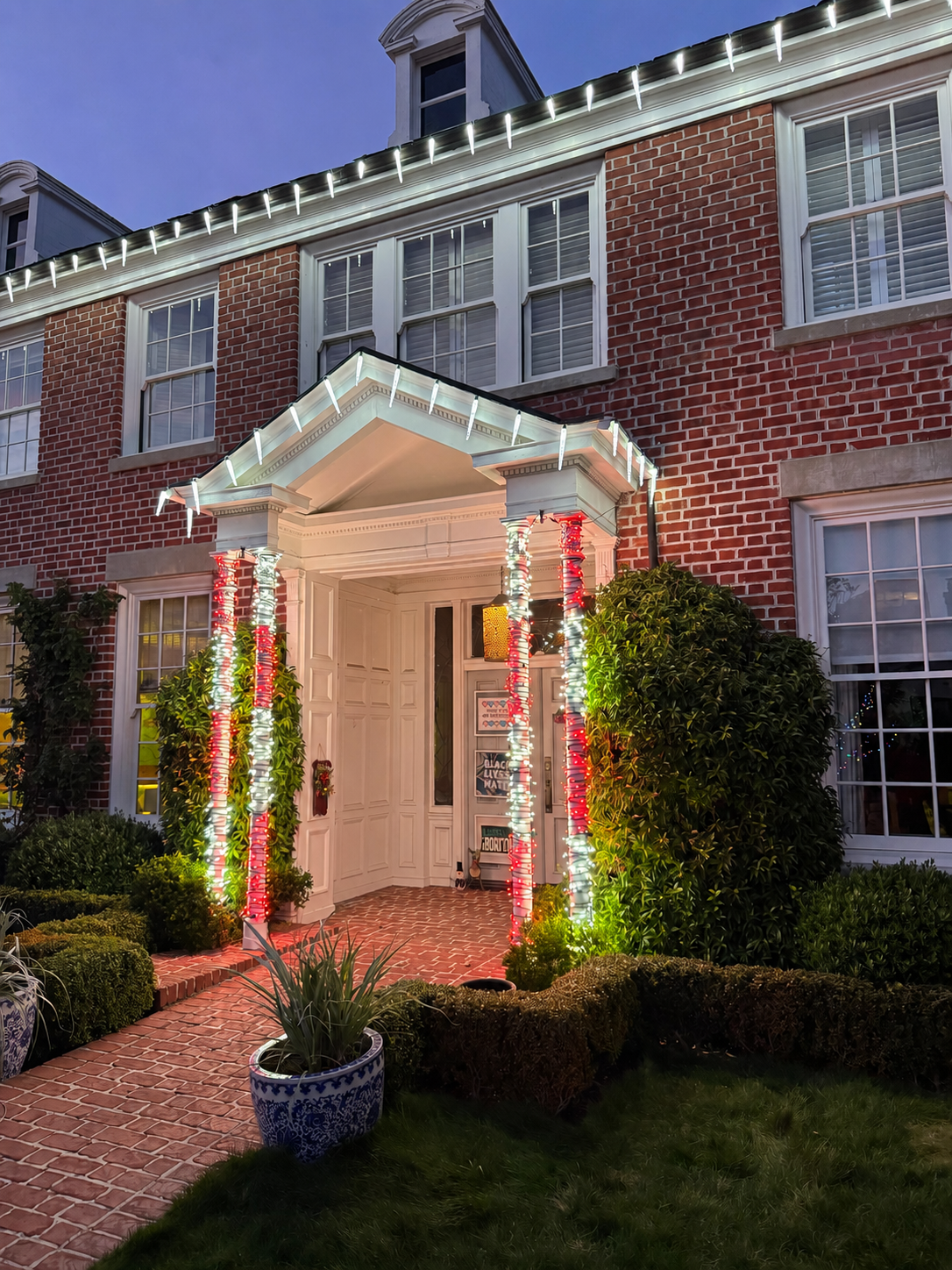 Holiday lighting and red bows at a residential entry