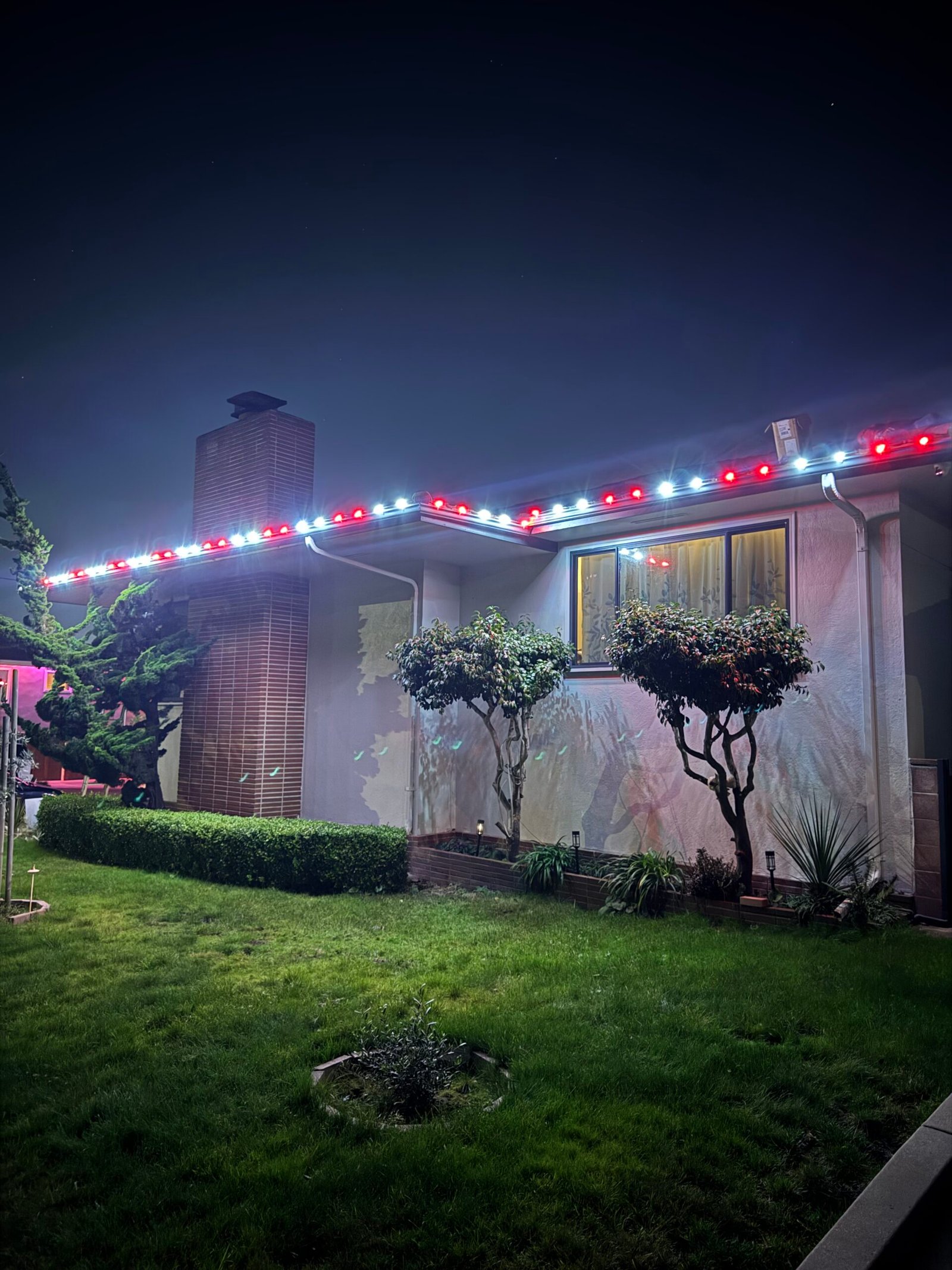Red and white custom holiday roofline lighting
